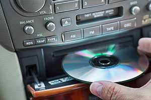 man's hand inserting CD in car player
